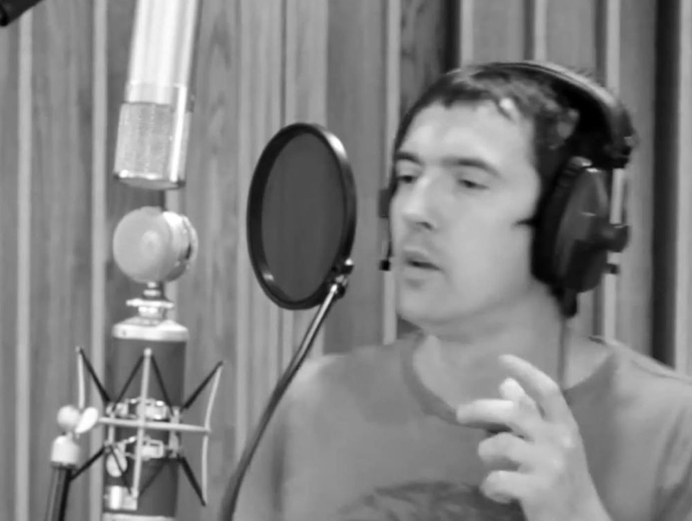 Benn Willis singing into a studio microphone